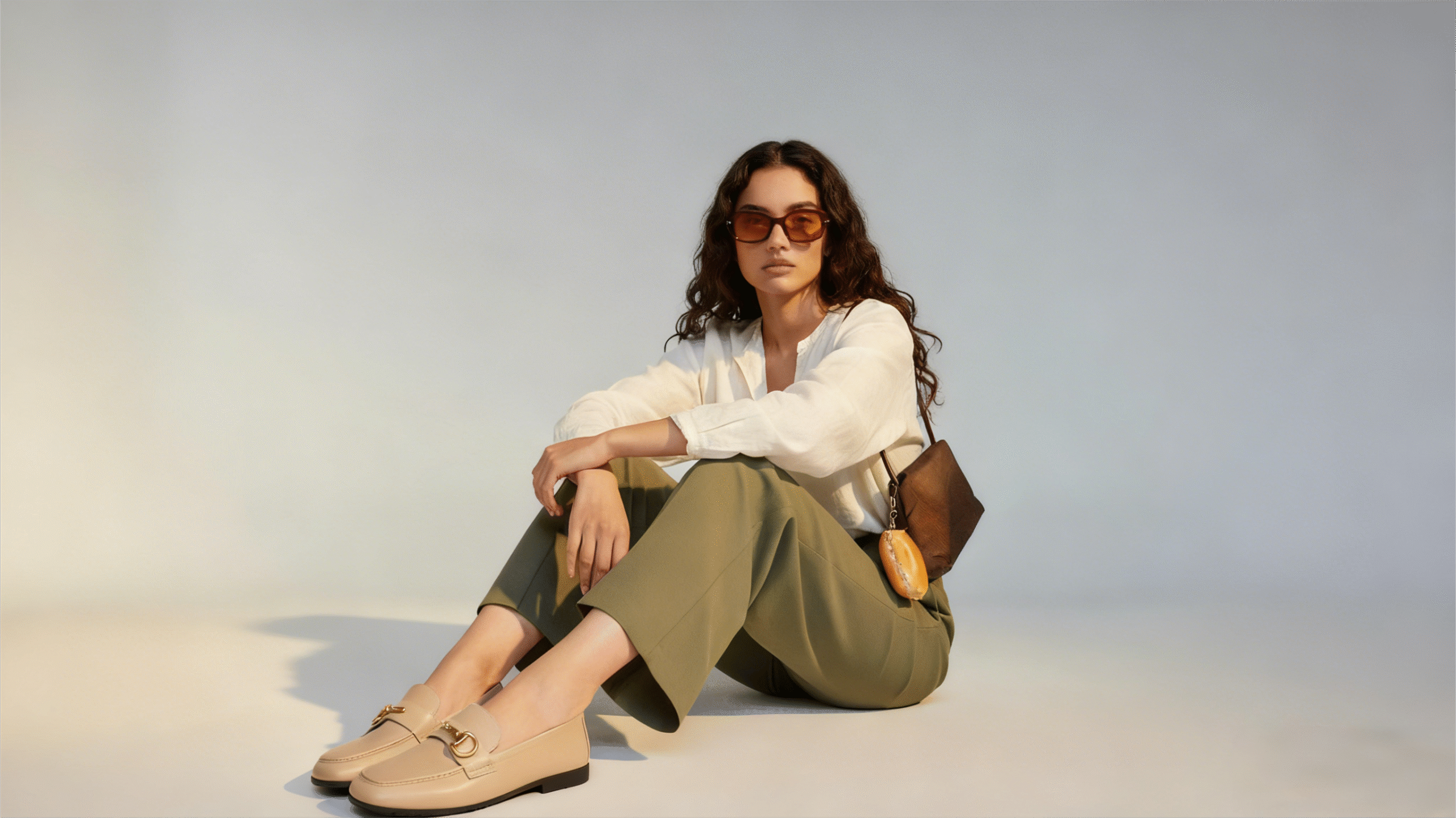 homepage A stylish working woman wearing loafers sat on the floor